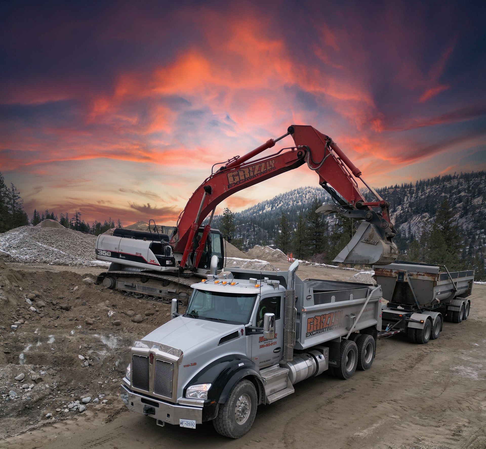 Grizzly Excavation LTD – Grizzly Scenic A large truck parked beside a large excavator on a construction site, showcasing heavy machinery in operation