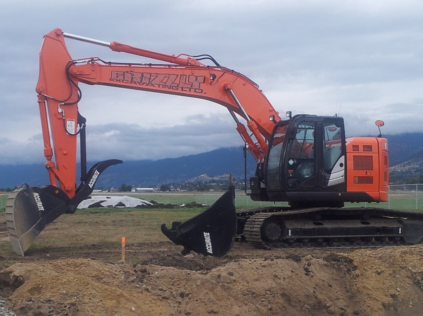 An orange excavator positioned on a mound of dirt, showcasing its heavy machinery in a construction setting